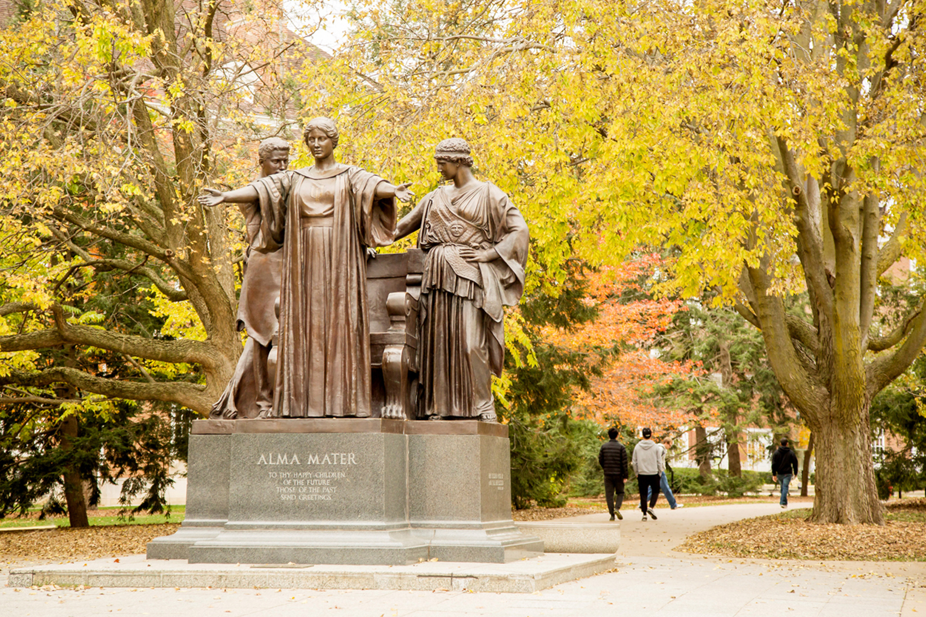 Bronze Alma Mater statue surrounded by trees