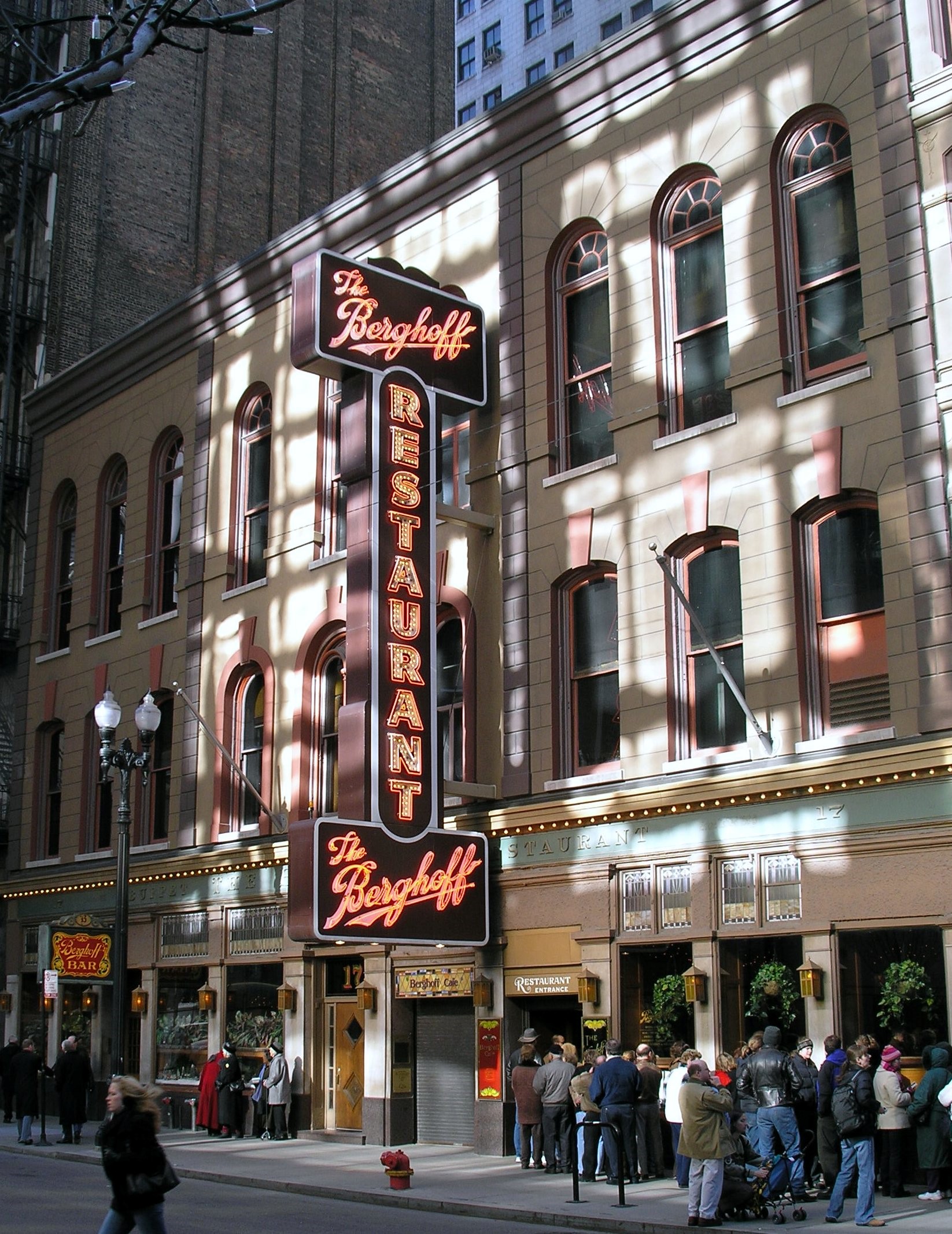 Photo of exterior entrance to The Berghoff Restaurant with large vertical marquee sign overhead